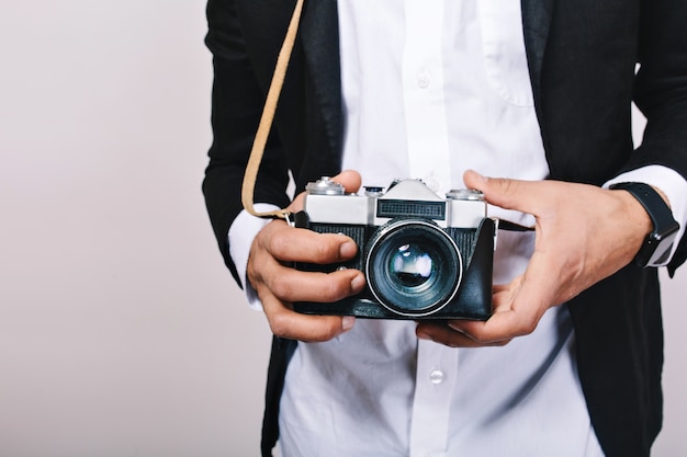 Stylish image of retro camera in hands of handsome guy in suit. Leisure, journalist, photograph, hobbies, having fun.