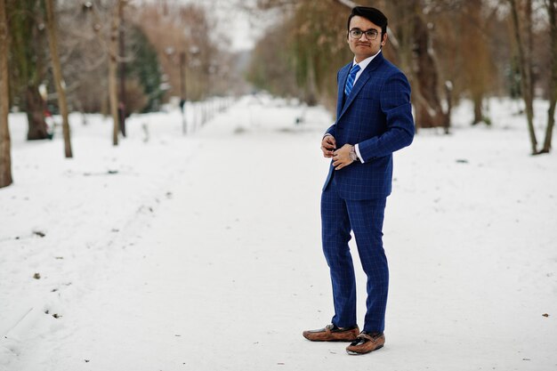 Stylish indian business man in suit and glasses posed at winter day outdoor