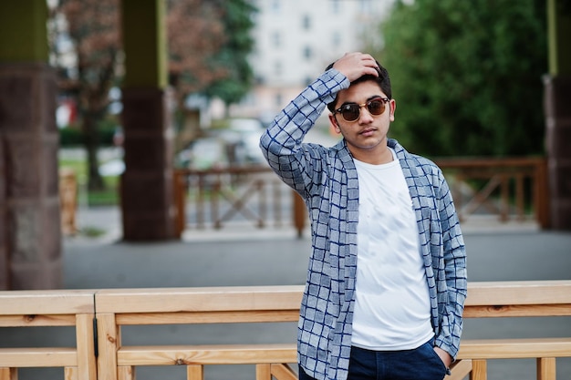 Stylish indian young man at sunglasses wear casual posed outdoor