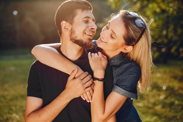 Stylish loving couple standing in a park. 