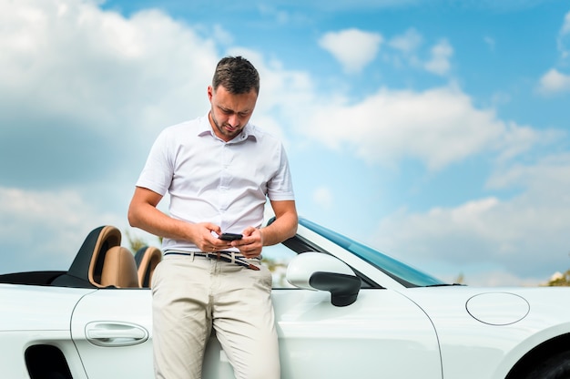 Stylish man looking at phone front view