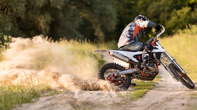 Stylish man riding motorbike in the forrest