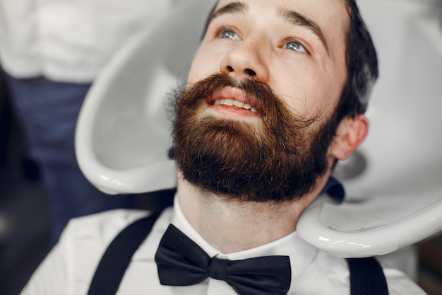 Free photo stylish man sitting in a barbershop