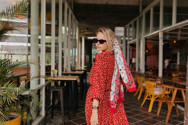 Stylish modern woman with blond hair wearing red summer dress