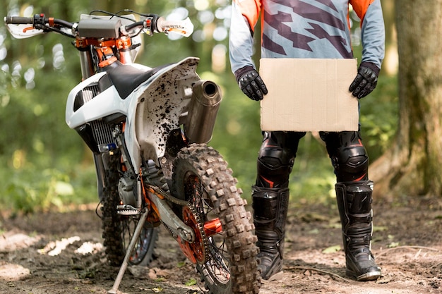 Free photo stylish motorbike rider holding cardboard sign