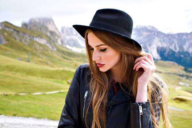 Stylish portrait of elegant woman, posing at Italian Dolomites mountains