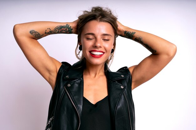 Stylish positive woman with tattos black lather and bright lips happy emotional face white background