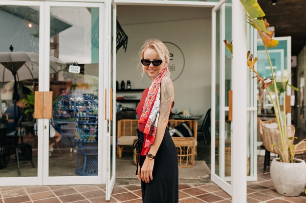 Stylish pretty caucasian woman with silk scarf in the head