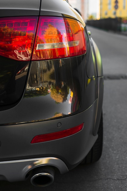 Stylish rear light on new black automobile on route 