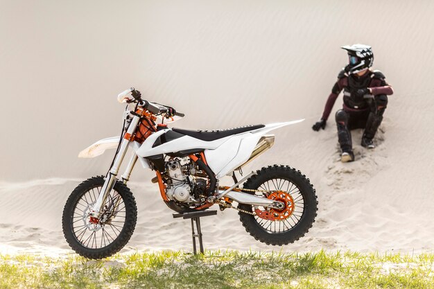 Stylish rider with motorbike in the desert