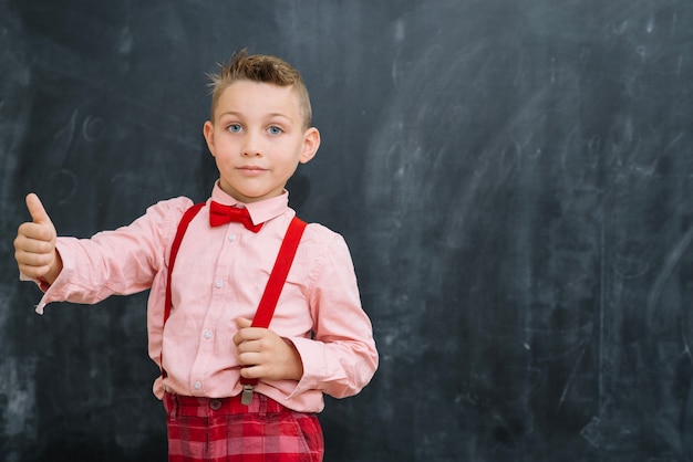 Free photo stylish schoolkid gesturing at blackboard