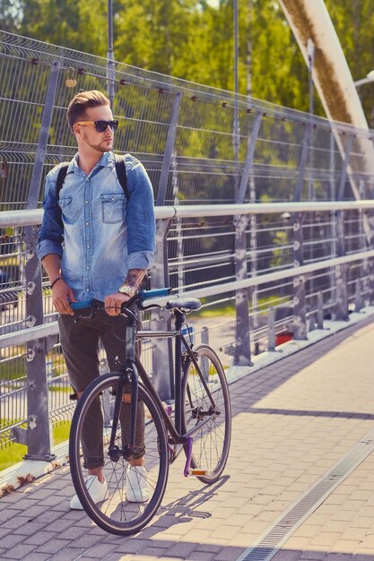 Stylish single speed cyclist on a bridge.