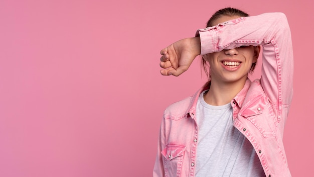 Stylish teen boy in pink posing with copy space