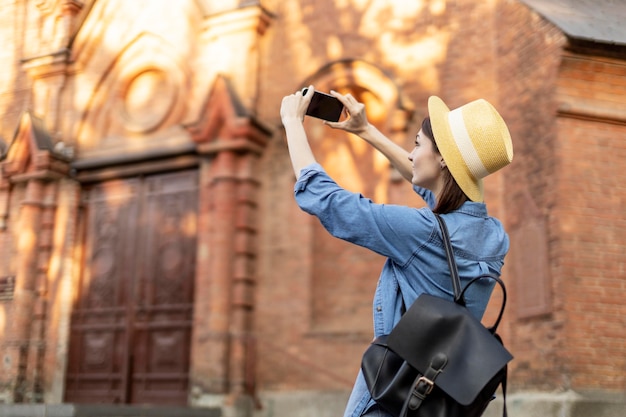 Free Photo stylish tourist with hat taking pictures on vacation