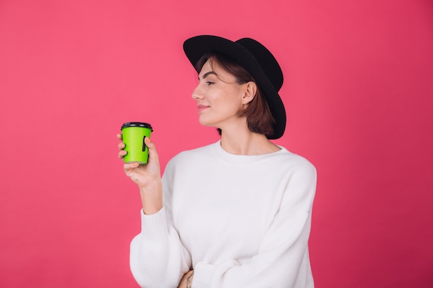 Free Photo stylish woman in casual white sweater and hat on pink red wall