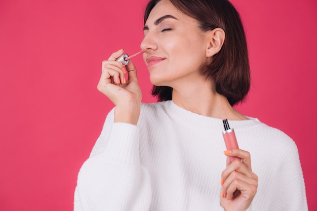 Free photo stylish woman in casual white sweater on pink red wall