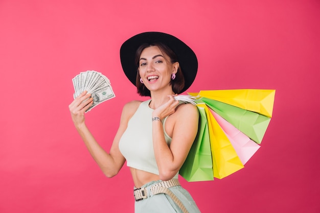 Stylish woman in hat on pink red wall