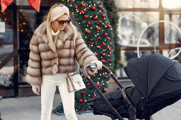 Free photo stylish woman walking in a city with carriage