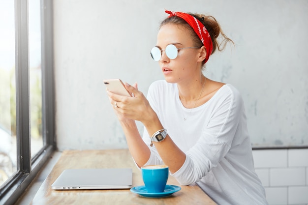 Free photo stylish woman wearing bandana sitting in cafe