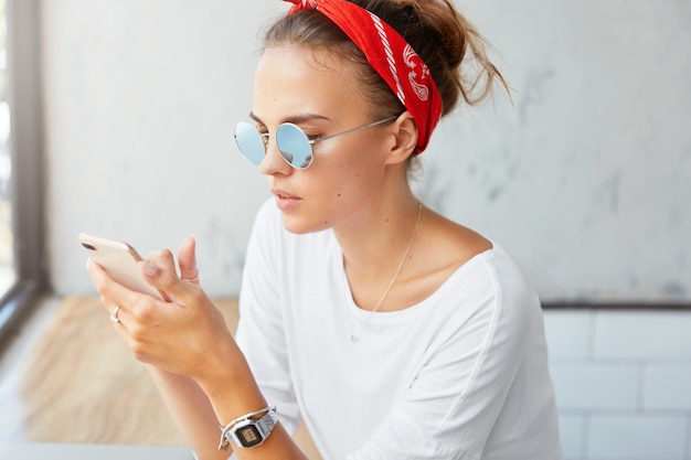 Stylish woman wearing bandana sitting in cafe