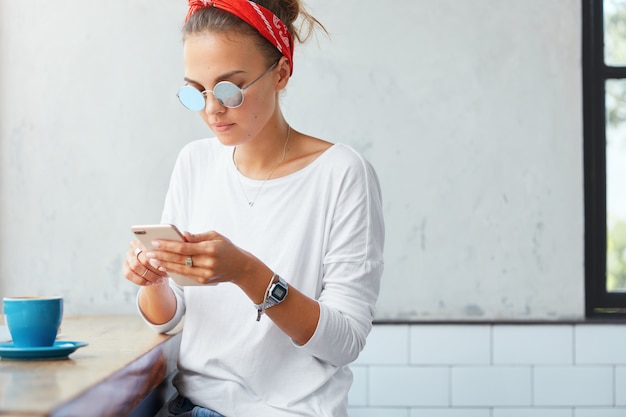 Stylish woman wearing bandana sitting in cafe