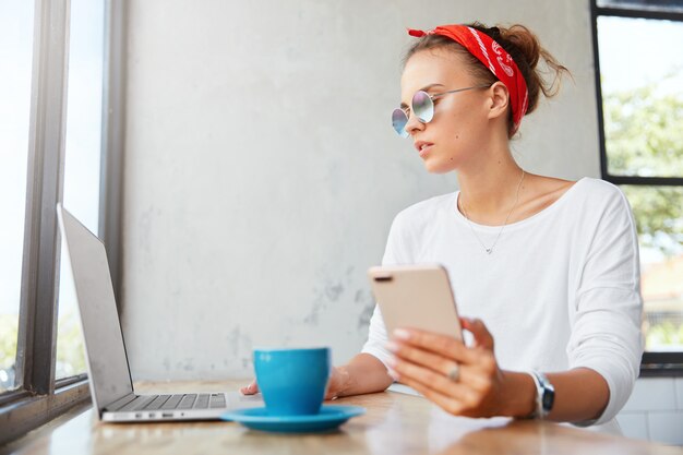 Stylish woman wearing bandana sitting in cafe