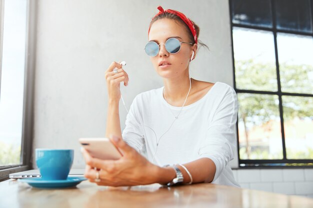 Stylish woman wearing bandana sitting in cafe