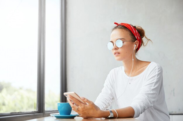 Stylish woman wearing bandana sitting in cafe