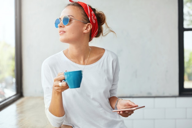 Stylish woman wearing bandana sitting in cafe