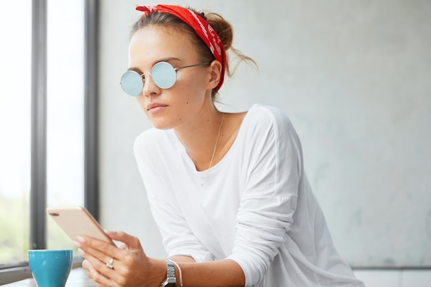 Stylish woman wearing bandana sitting in cafe