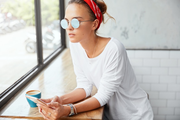 Free photo stylish woman wearing bandana sitting in cafe