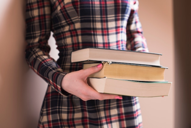 Stylish woman with three thick books