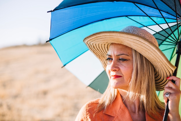 Free photo stylish woman with umbrella on nature