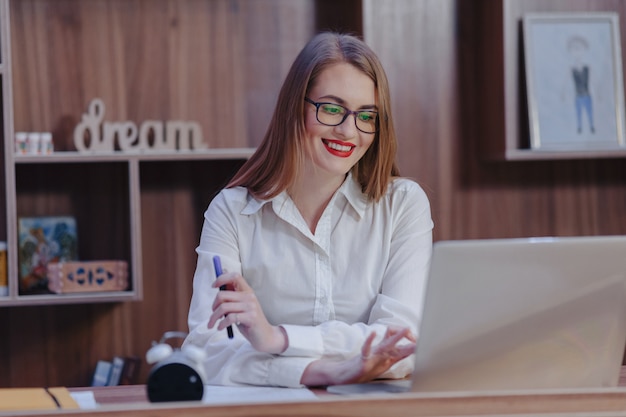 Stylish woman works at a laptop desk in a modern office