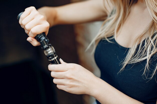 Stylish young girl  in a city with vape