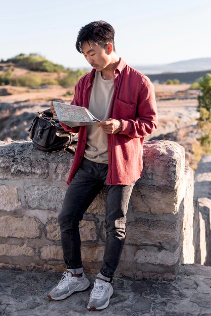 Stylish young man checking map