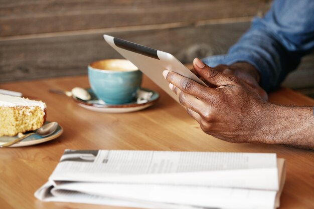 Stylish young man sitting in cafe with tablet