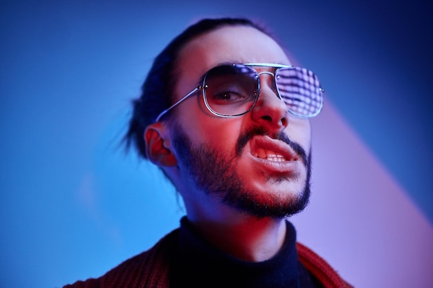 Free Photo stylish young man in sunglasses is showing aggressive emotion while showing his teeth.