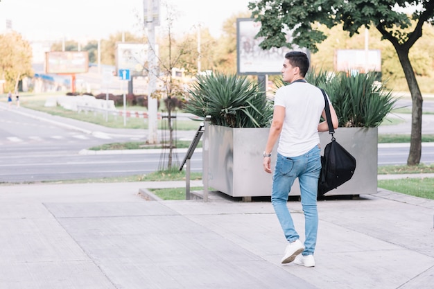 Stylish young man walking on street