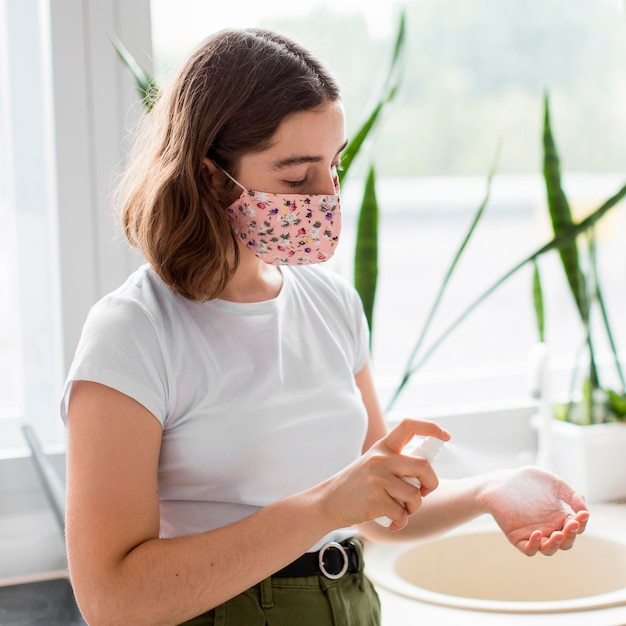 Stylish young woman disinfecting hands