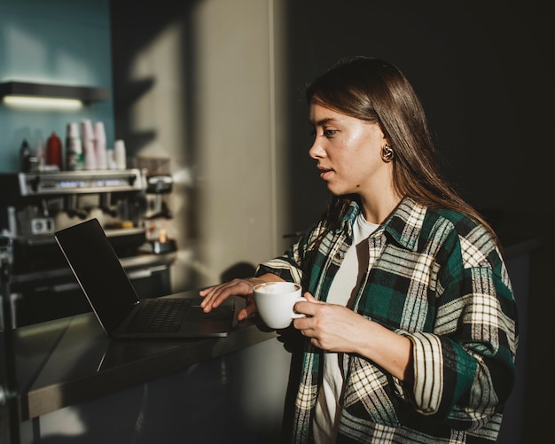 Free photo stylish young woman enjoying coffee