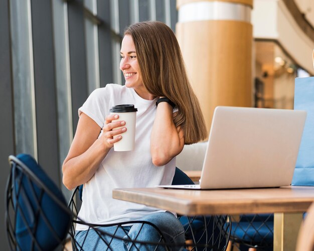 Stylish young woman holding coffee cup