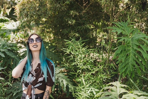 Stylish young woman standing in the forest