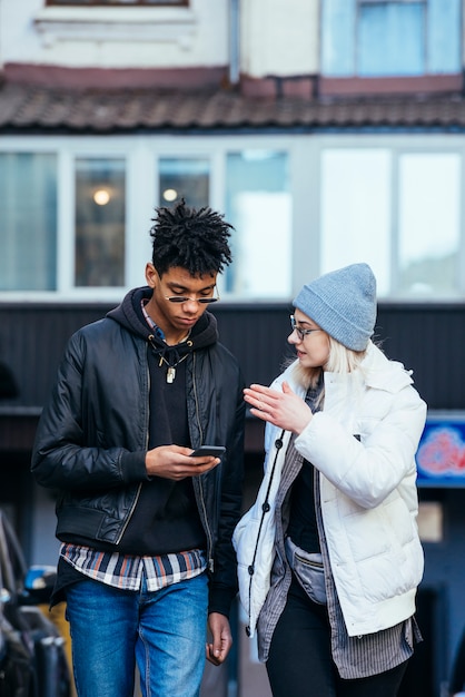 Stylish young woman talking to her handsome boyfriend using mobile phone