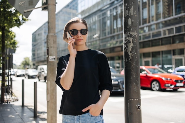 Free photo stylish young woman talking on phone at the city