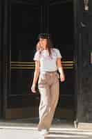 Free photo stylish young woman with cap over her head walking on street