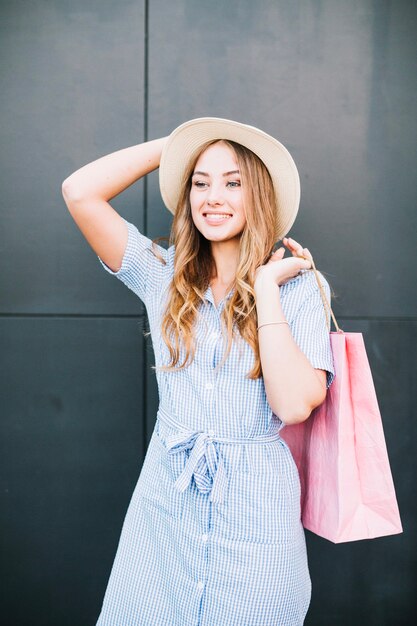 Stylish young woman with pink paper bags