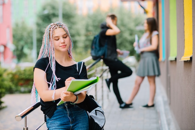 Stylish youngster writing in notepad