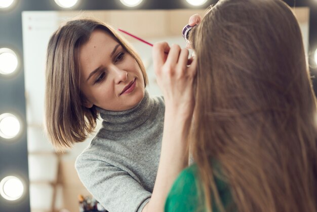 Stylist using eyeliner on anonymous model