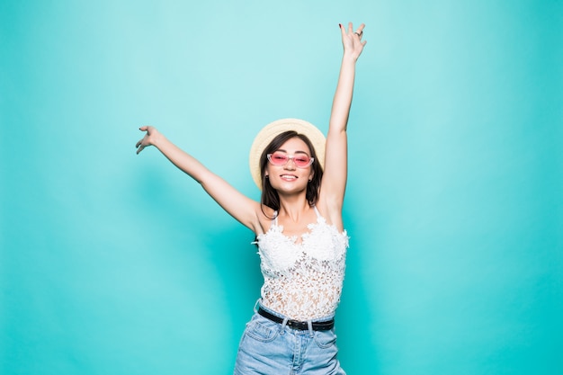 Success asian woman dancing and celebrating standing in full length isolated on green wall.